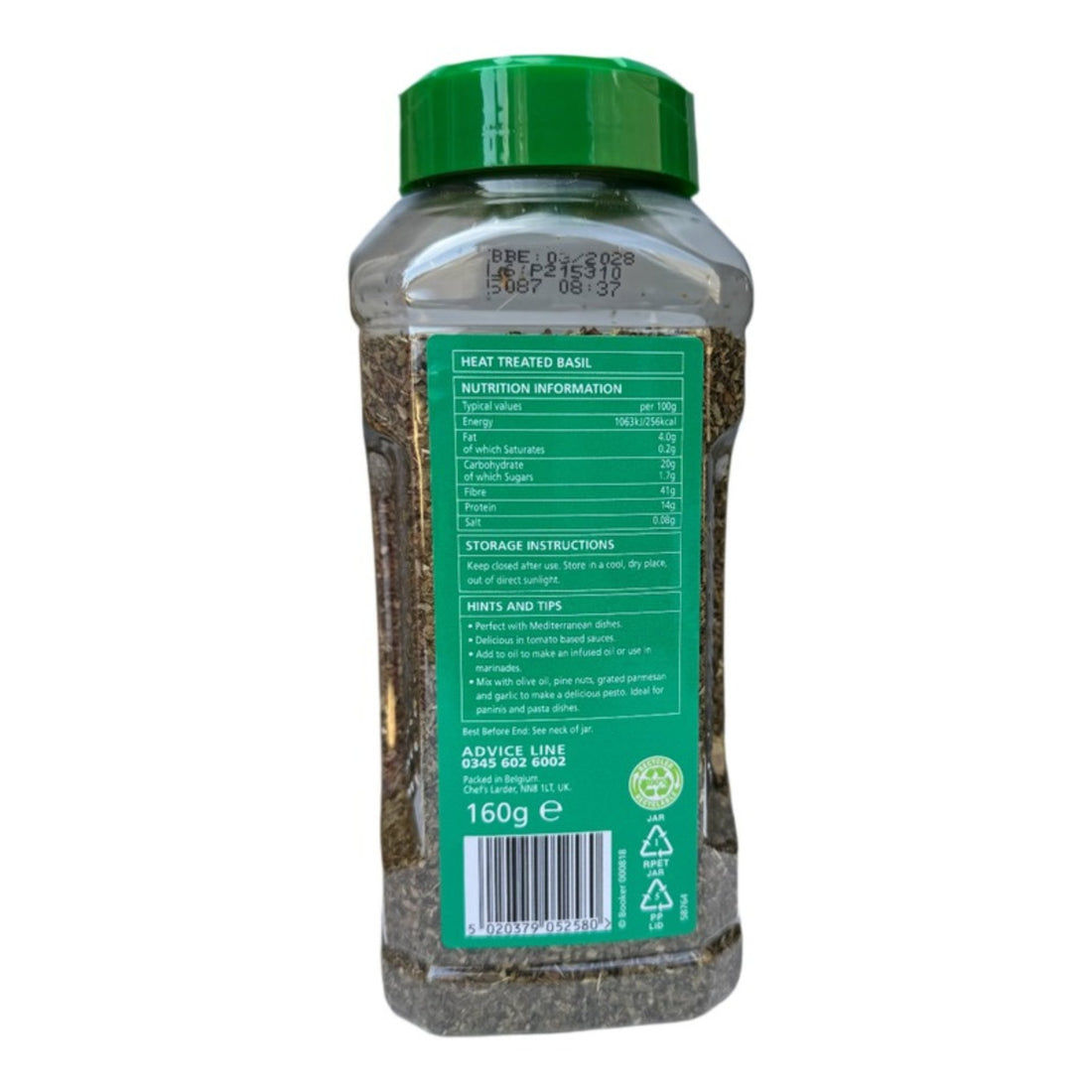 dried basil jar with green lid and label on a gray background